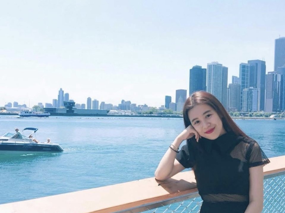 Hồ Trần Ngọc Diễm bên bờ nước với đường chân trời thành phố Singapore