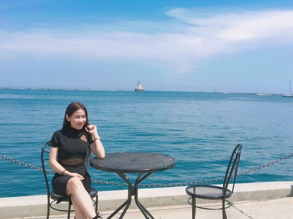 Hồ Trần Ngọc Diễm ngồi bên bàn cà phê nhìn ra biển